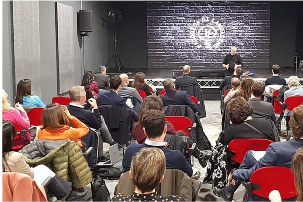 Partecipanti aziendali durante il debriefing guidato nella sala teatro