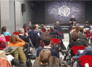Partecipanti aziendali durante il debriefing guidato nella sala teatro