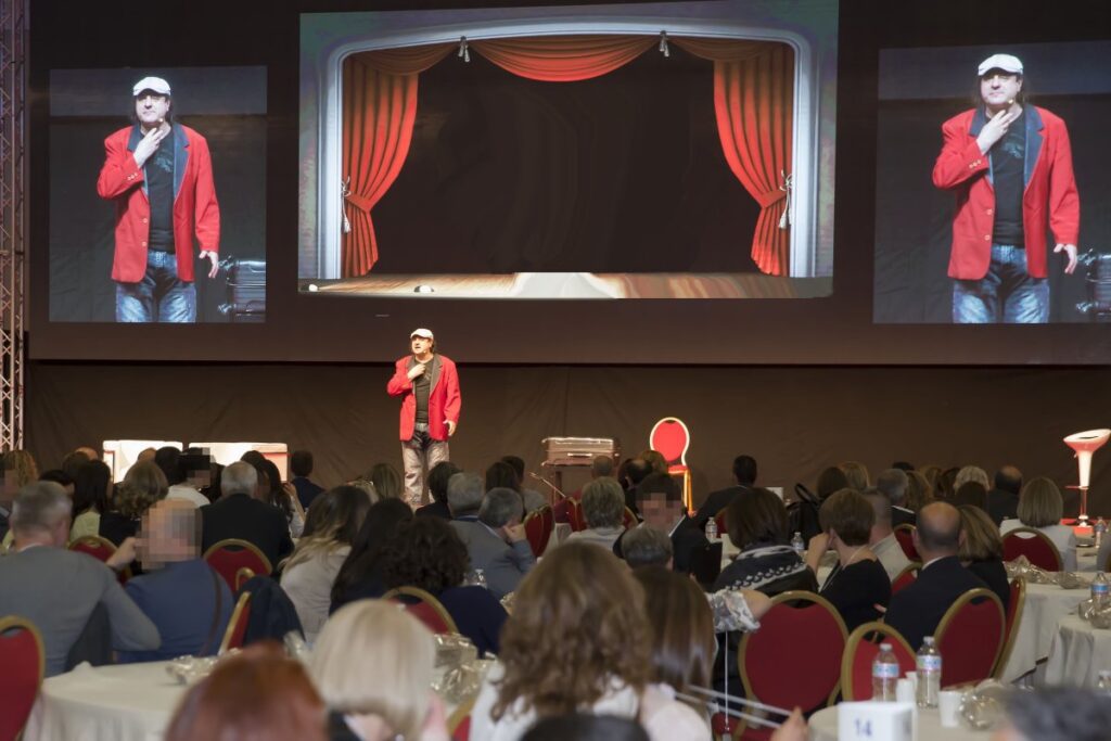 Partecipanti al quiz show aziendale con pulsantiere e schermo proiettato