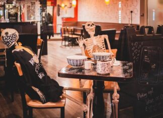 Scheletri seduti a cena in un locale per evento Halloween