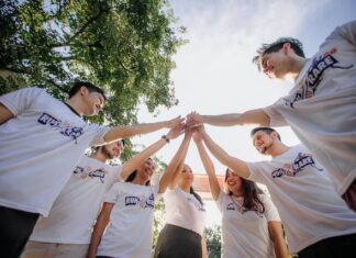 Team aziendale unito in cerchio durante un'attività di team building creativo all’aperto