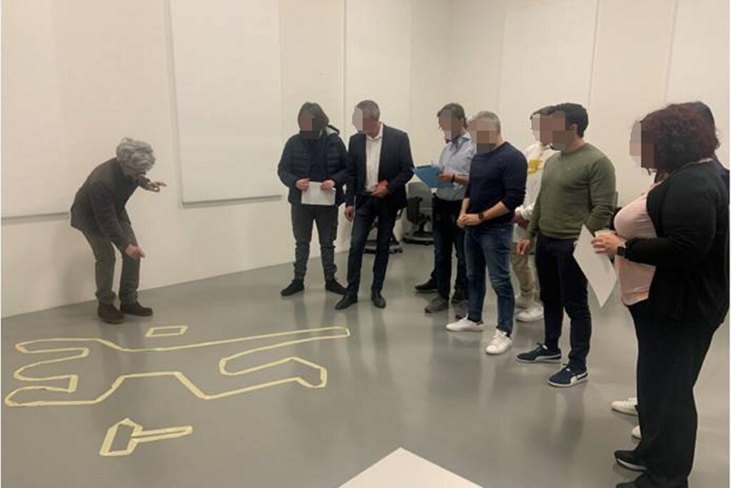 Partecipanti aziendali coinvolti in una scena investigativa durante il format
