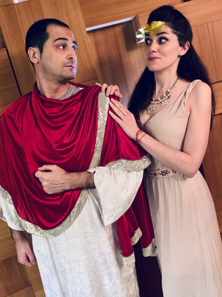 Attori durante una Cena con Delitto in costume romano, mentre recitano una scena teatrale